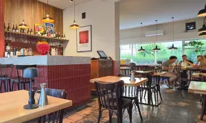 Wnętrze restauracji z barem, stołami i ludźmi jedzącymi posiłek. Klimatyczna restauracja it.