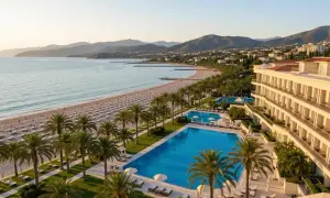 Luksusowy hotel z atrakcjami dla dorosłych, z basenami i prywatną plażą, otoczony palmami, z widokiem na morze i góry.