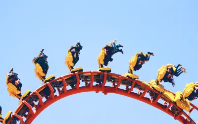 Mayan Energylandia: pędząca kolejka z pasażerami w żółtych wagonikach, doświadczającymi ekstremalnej prędkości i przeciążeń.