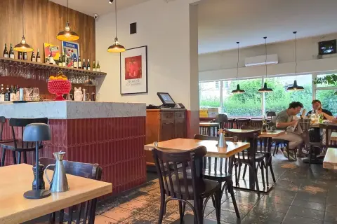 Wnętrze restauracji z barem, stołami i ludźmi jedzącymi posiłek. Klimatyczna restauracja it.