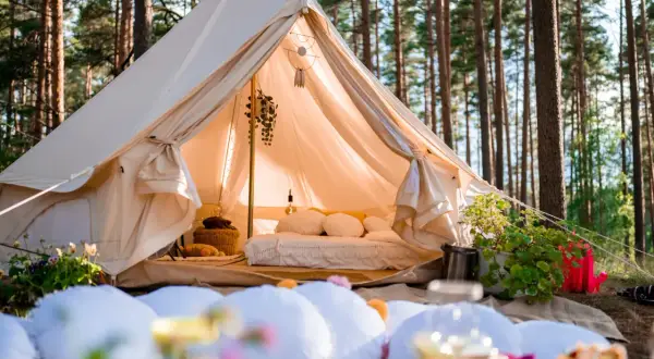 Glamping co to? Luksusowy namiot w lesie, z wygodnym łóżkiem i dekoracjami, zaprasza do odpoczynku na łonie natury.