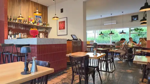 Wnętrze restauracji z barem, stołami i ludźmi jedzącymi posiłek. Klimatyczna restauracja it.