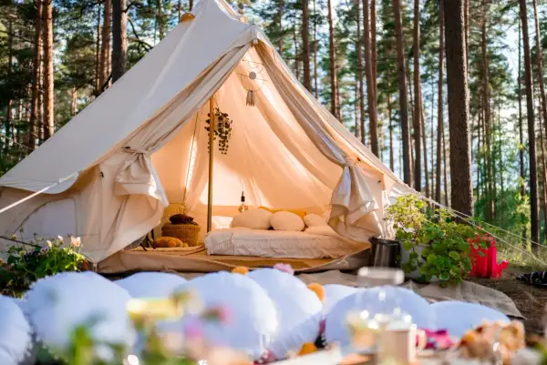Glamping co to? Luksusowy namiot w lesie, z wygodnym łóżkiem i dekoracjami, zaprasza do odpoczynku na łonie natury.